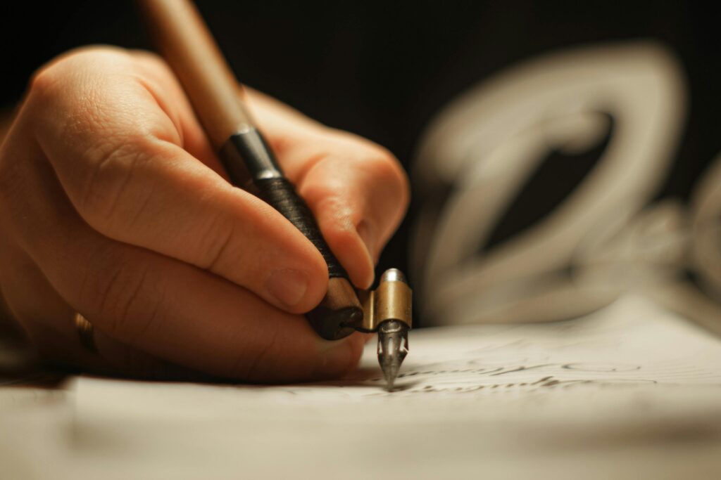 Common Mistakes Beginners Make While Learning French (And How to Avoid Them) Artistic close-up of a hand using an oblique pen for calligraphy.