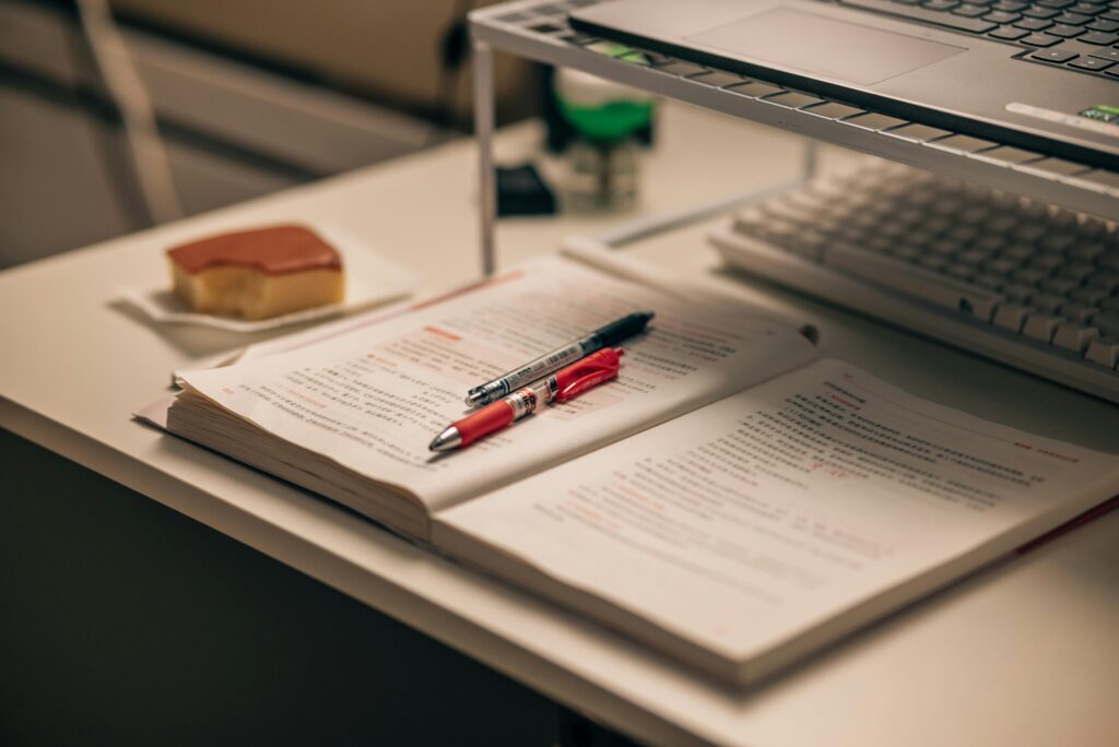 pexels photo 33936499 33936499 Open book with study notes, pens, and a laptop on a desk creating a focused study environment.